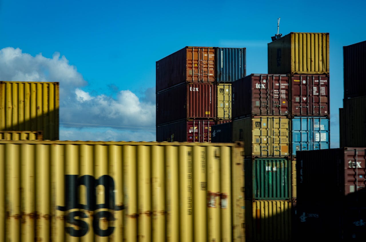 A vibrant display of stacked cargo containers against a clear blue sky.